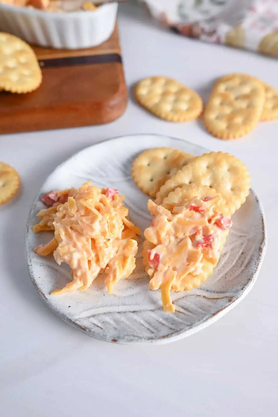 Pimento cheese and crackers on a small white plate.