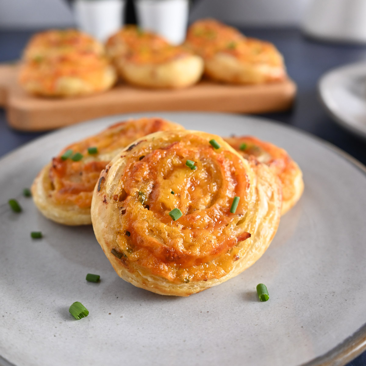 Close up of ham and cheese pinwheels on a gray plate.