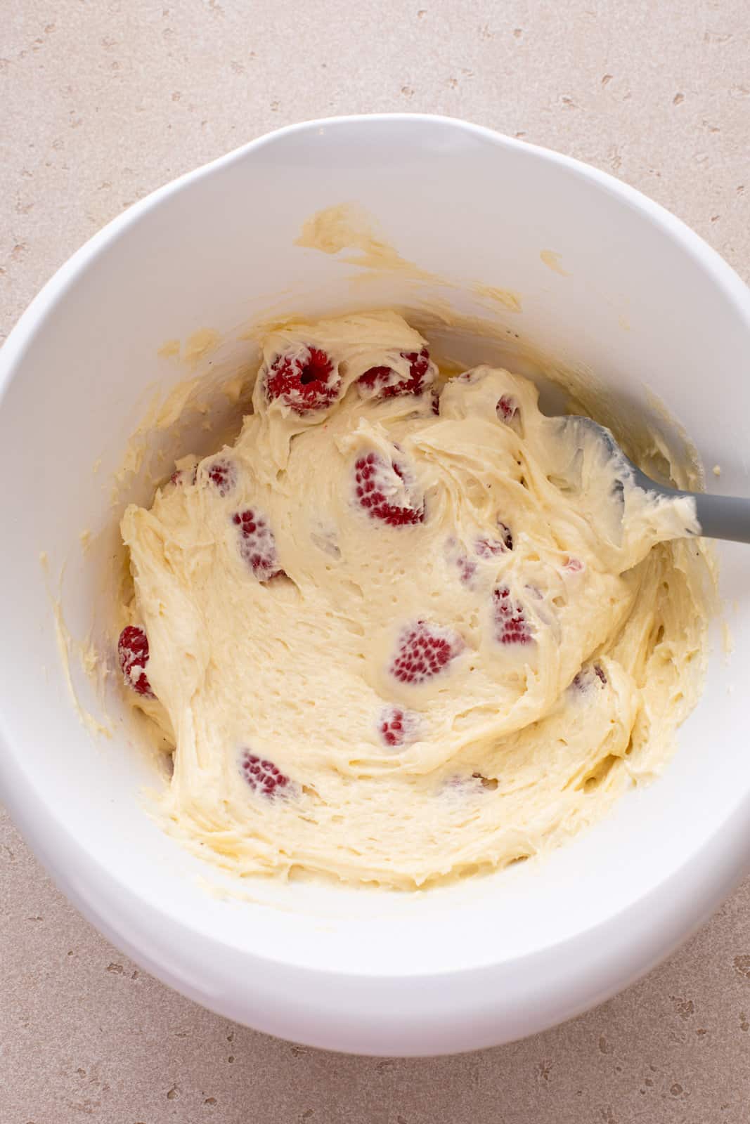 Raspberry coffee cake batter in a white bowl.