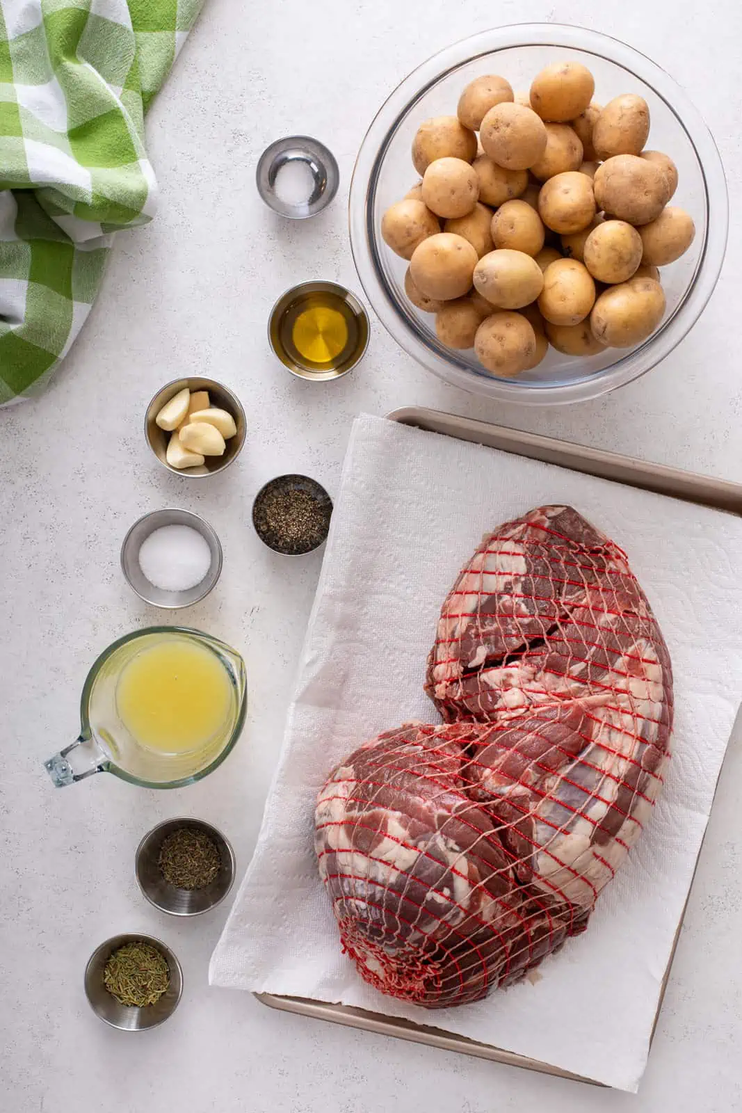 Ingredients for roasted boneless leg of lamb arranged on a countertop.