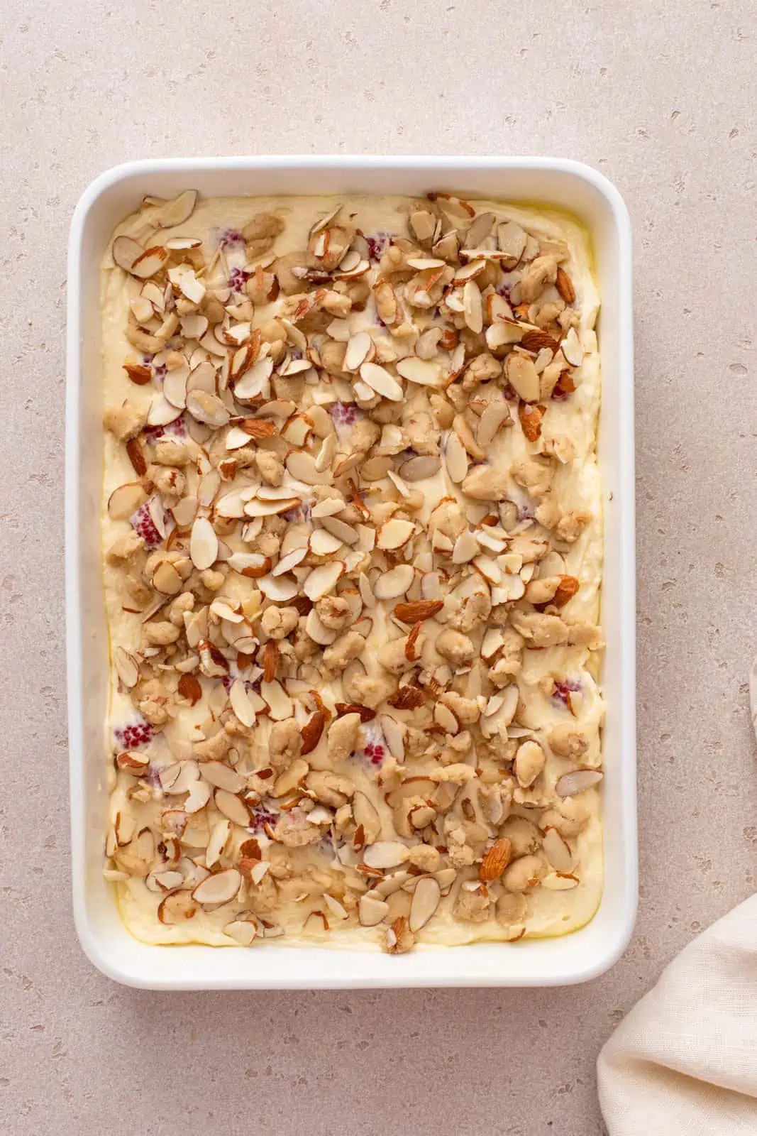 Unbaked raspberry coffee cake in a white pan, ready to go in the oven.