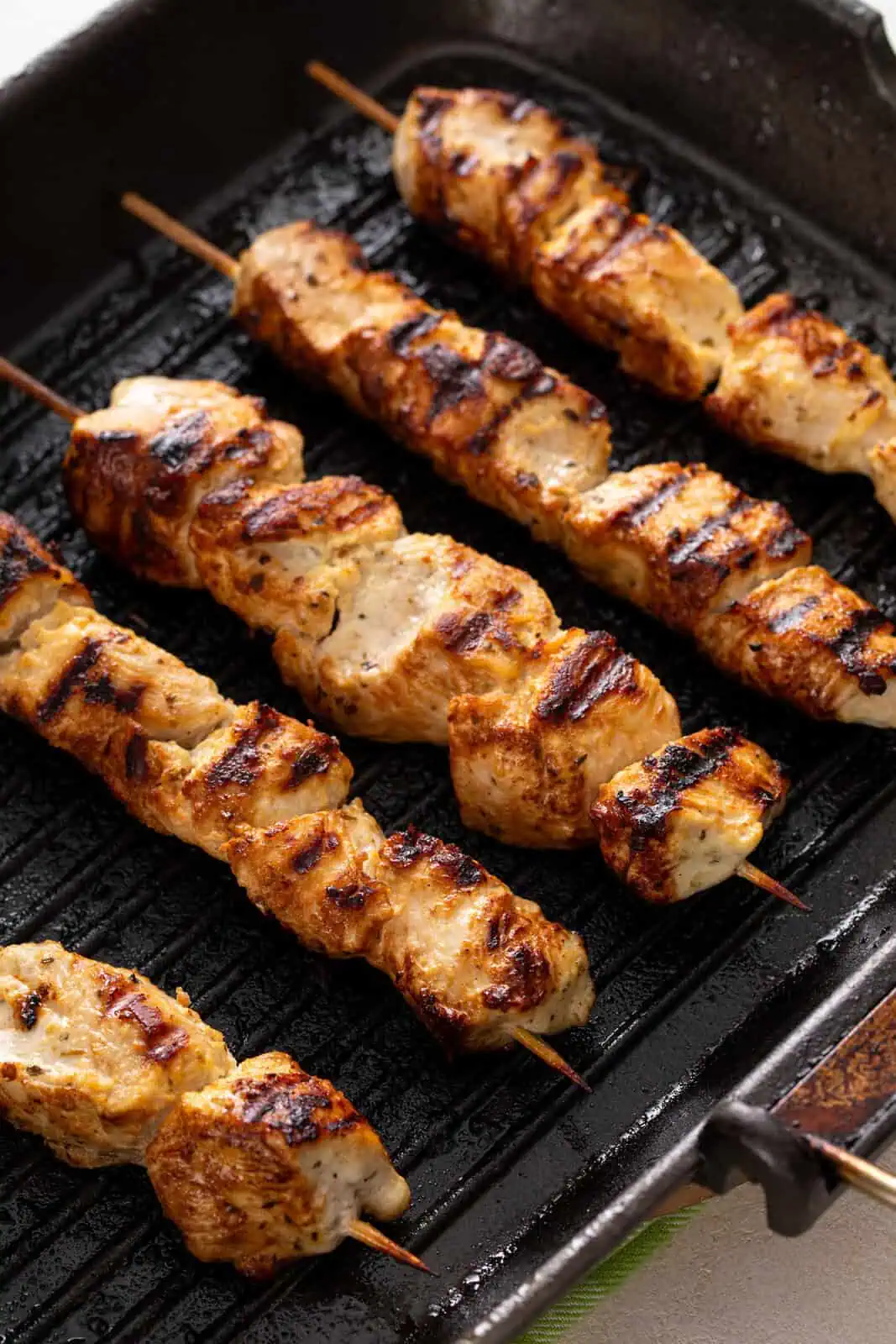 Grilled chicken skewers on a grill pan.