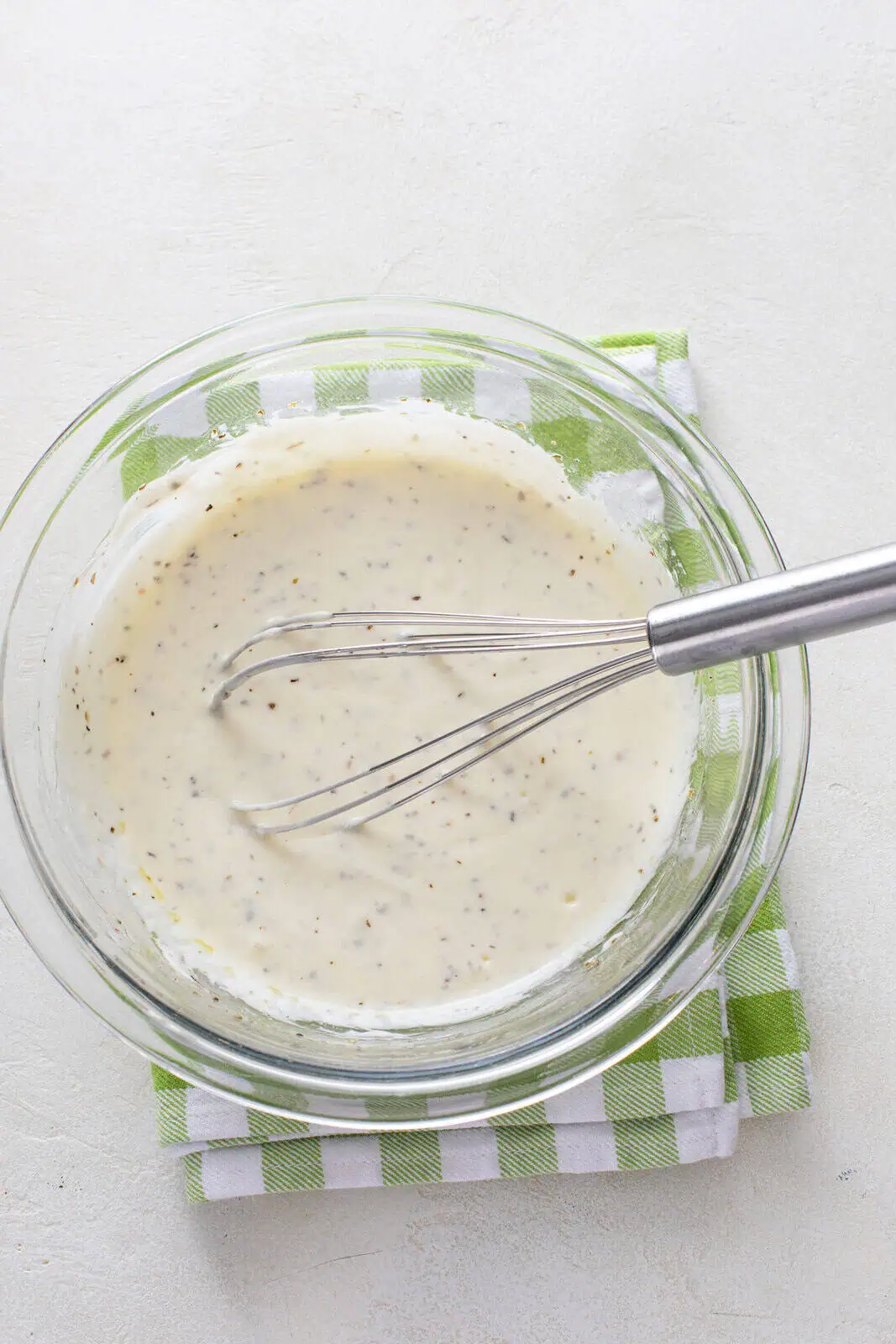 Yogurt marinade for chicken whisked in a glass bowl.
