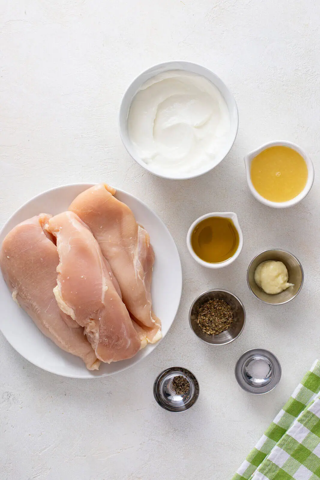 Ingredients for yogurt-marinated chicken skewers arranged on a countertop.