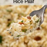 Fork holding up a bite of almond rice pilaf. Text overlay includes recipe name.