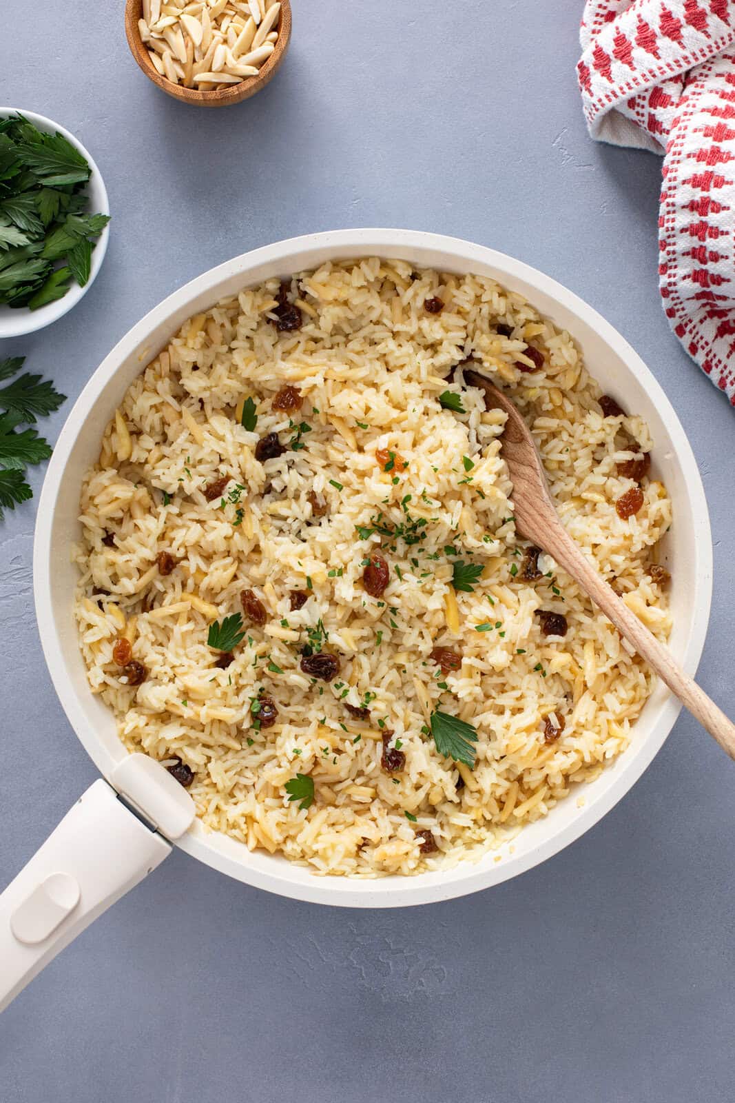 Almond rice pilaf mixed in a white saucepan.