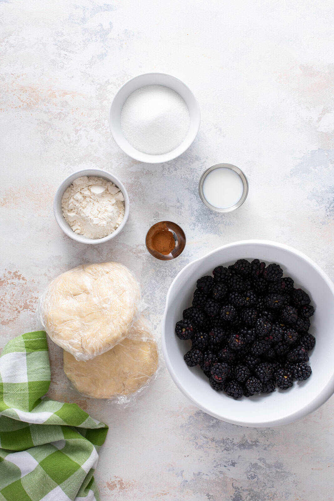 Blackberry pie ingredients arranged on a countertop.