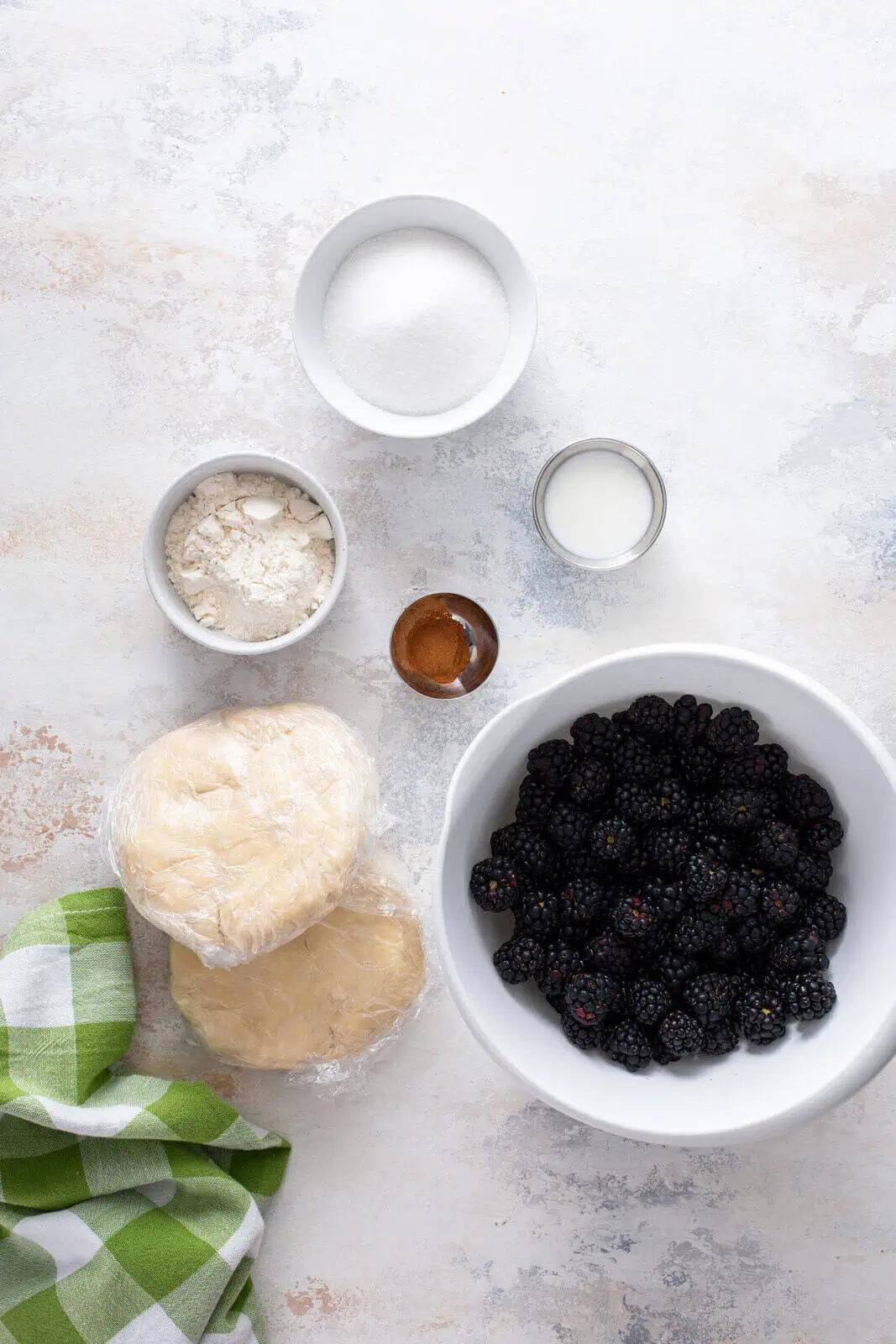 Blackberry pie ingredients arranged on a countertop.