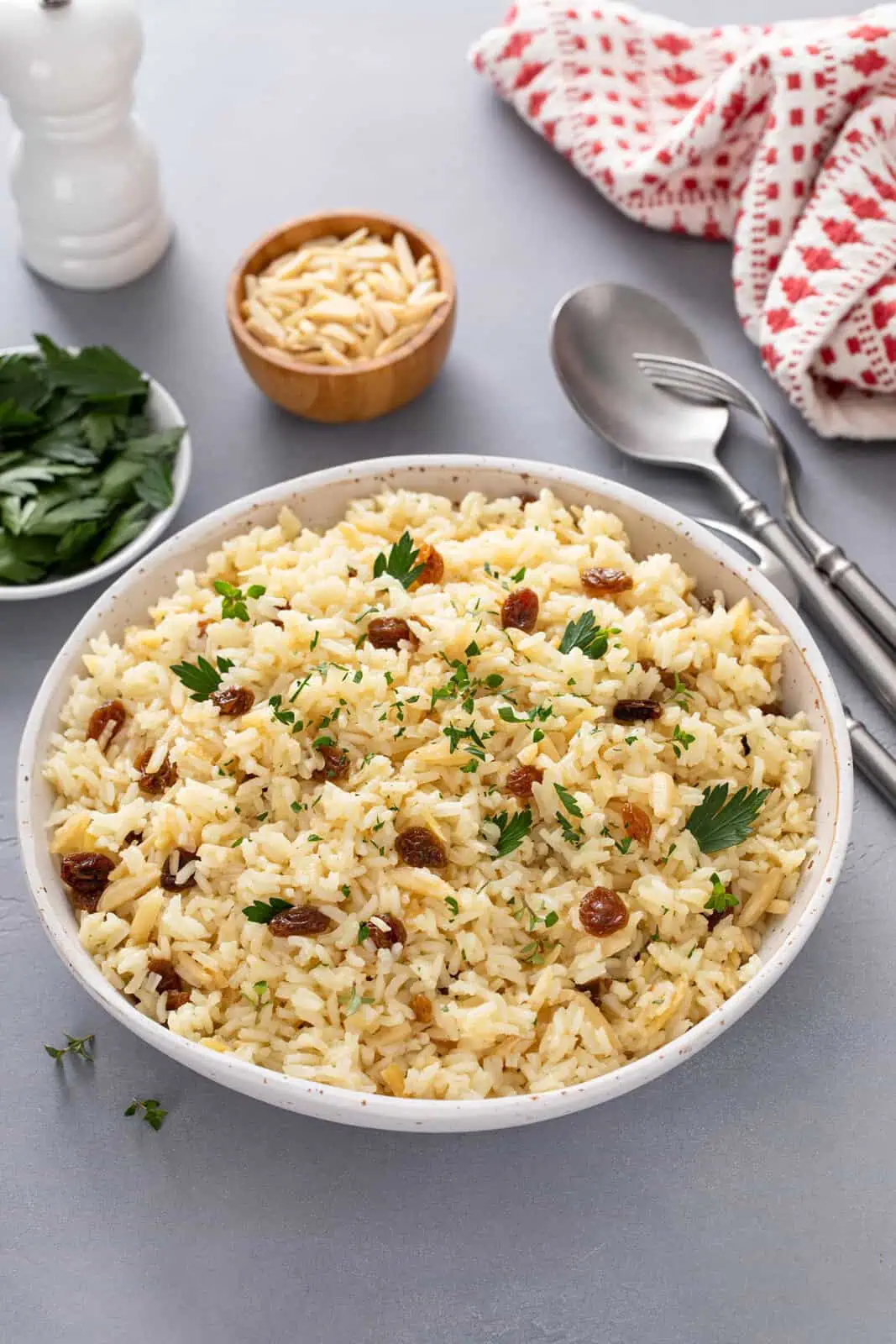 Almond rice pilaf in a large white serving bowl.