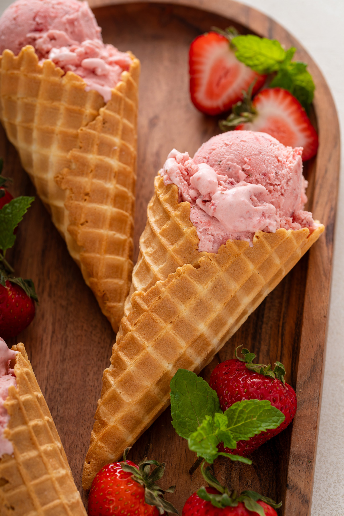 Close up of strawberry ice cream in a waffle cone.
