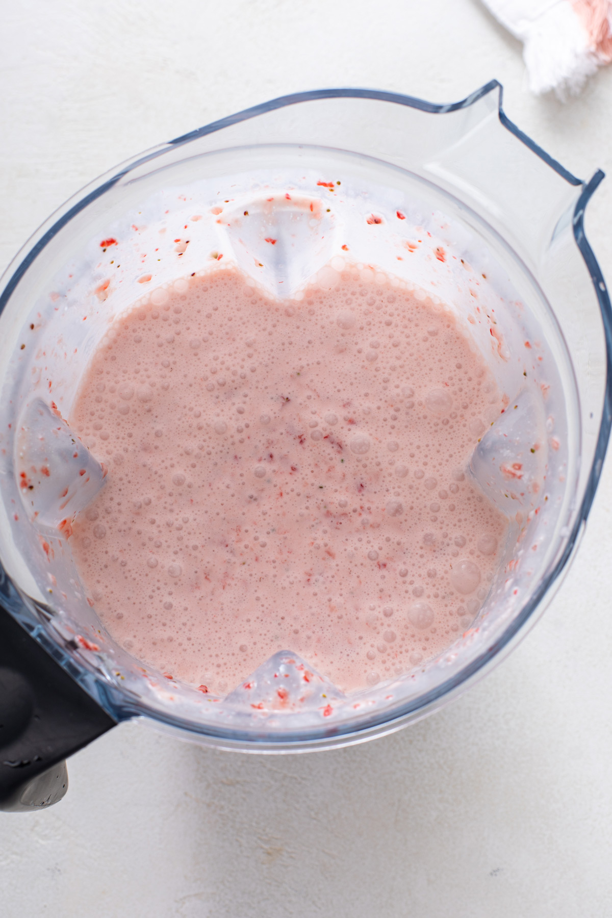 Strawberry ice cream base in a blender pitcher.