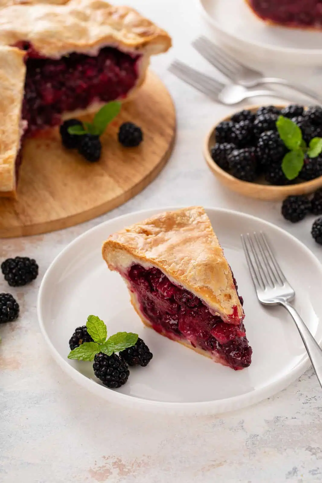 Slice of blackberry pie on a white plate.