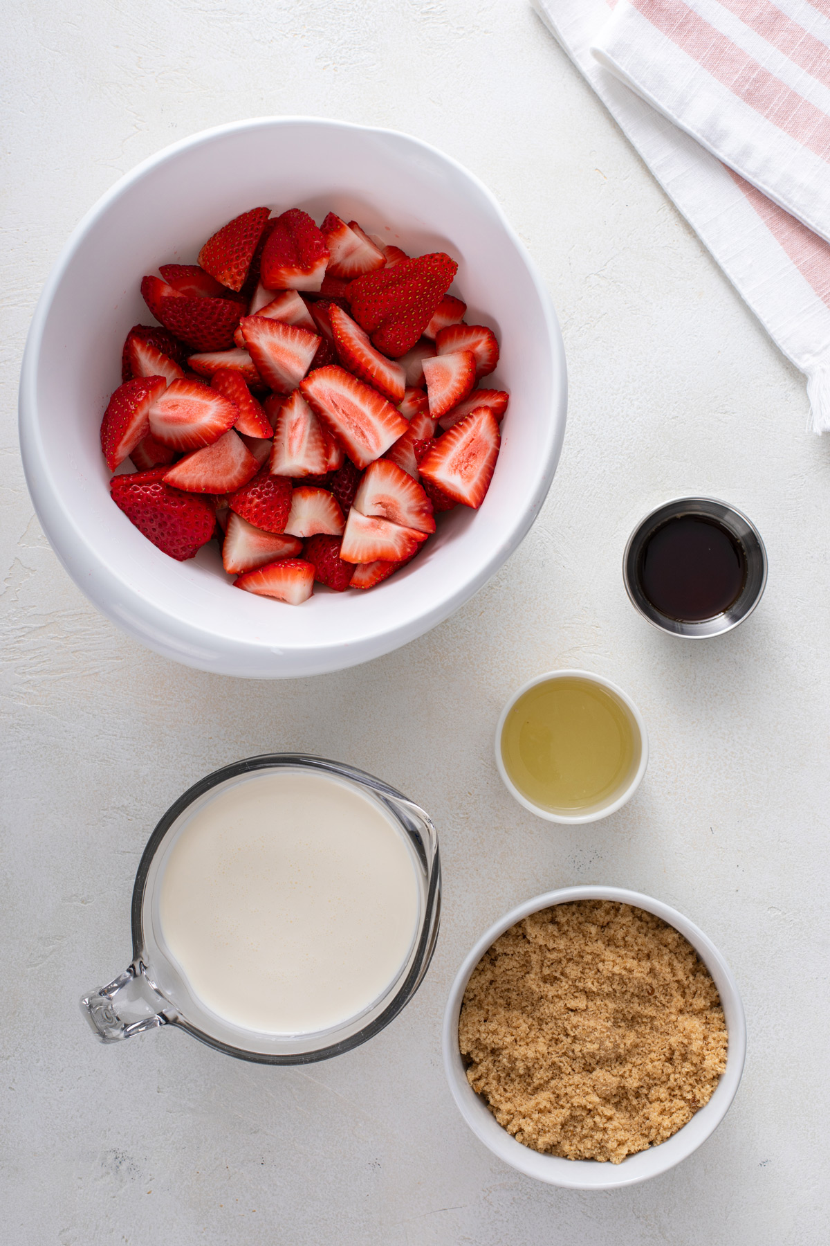 Ingredients for strawberry ice cream arranged on a countertop.