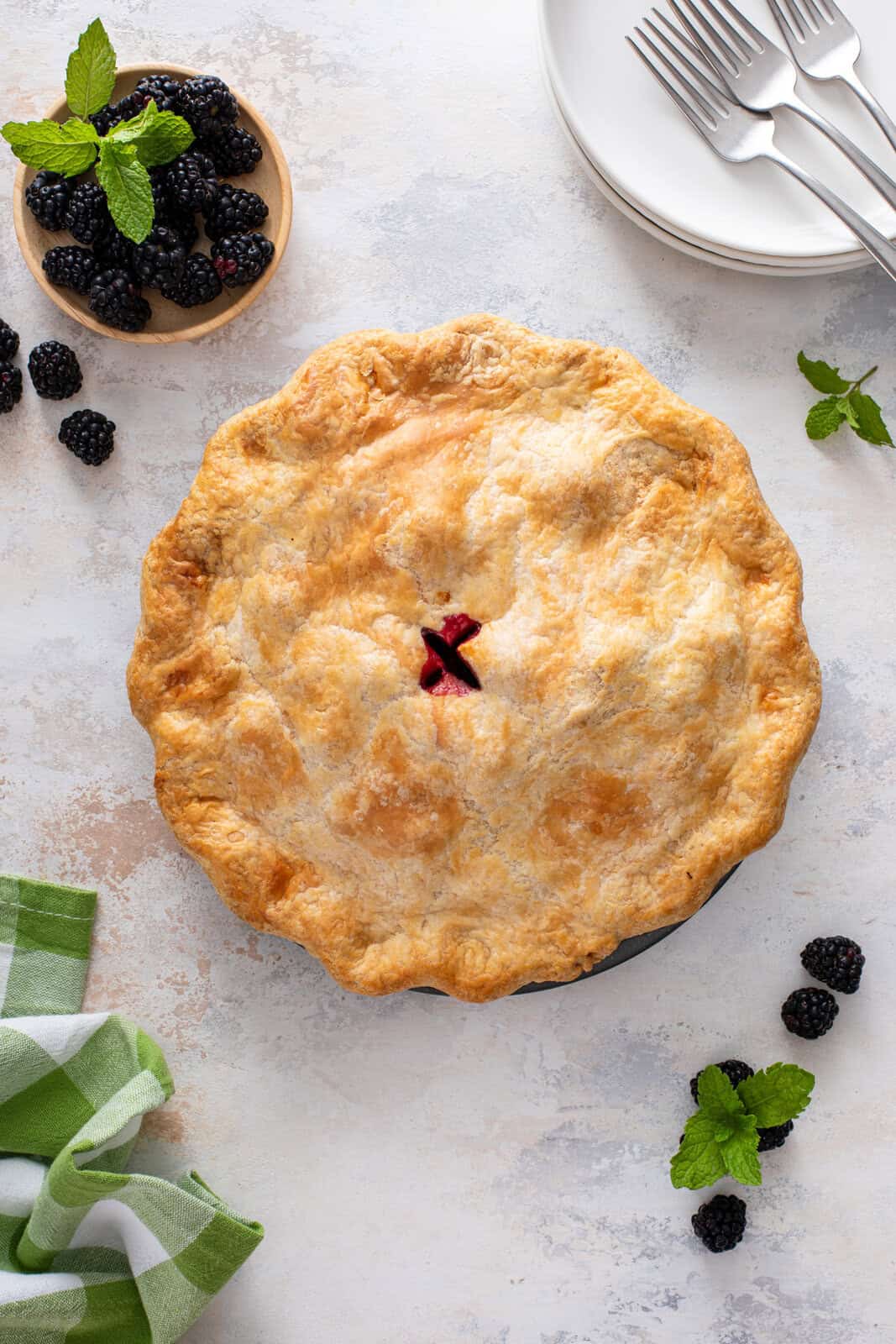 Whole blackberry pie on a countertop.