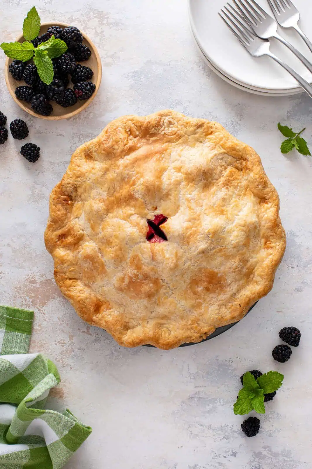Whole blackberry pie on a countertop.