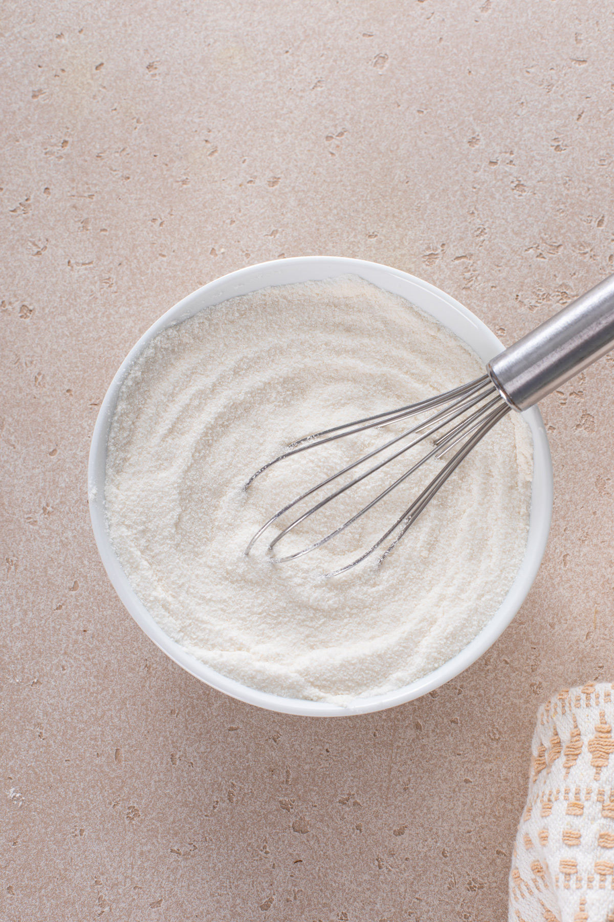 Flour and sugar whisked in a bowl.