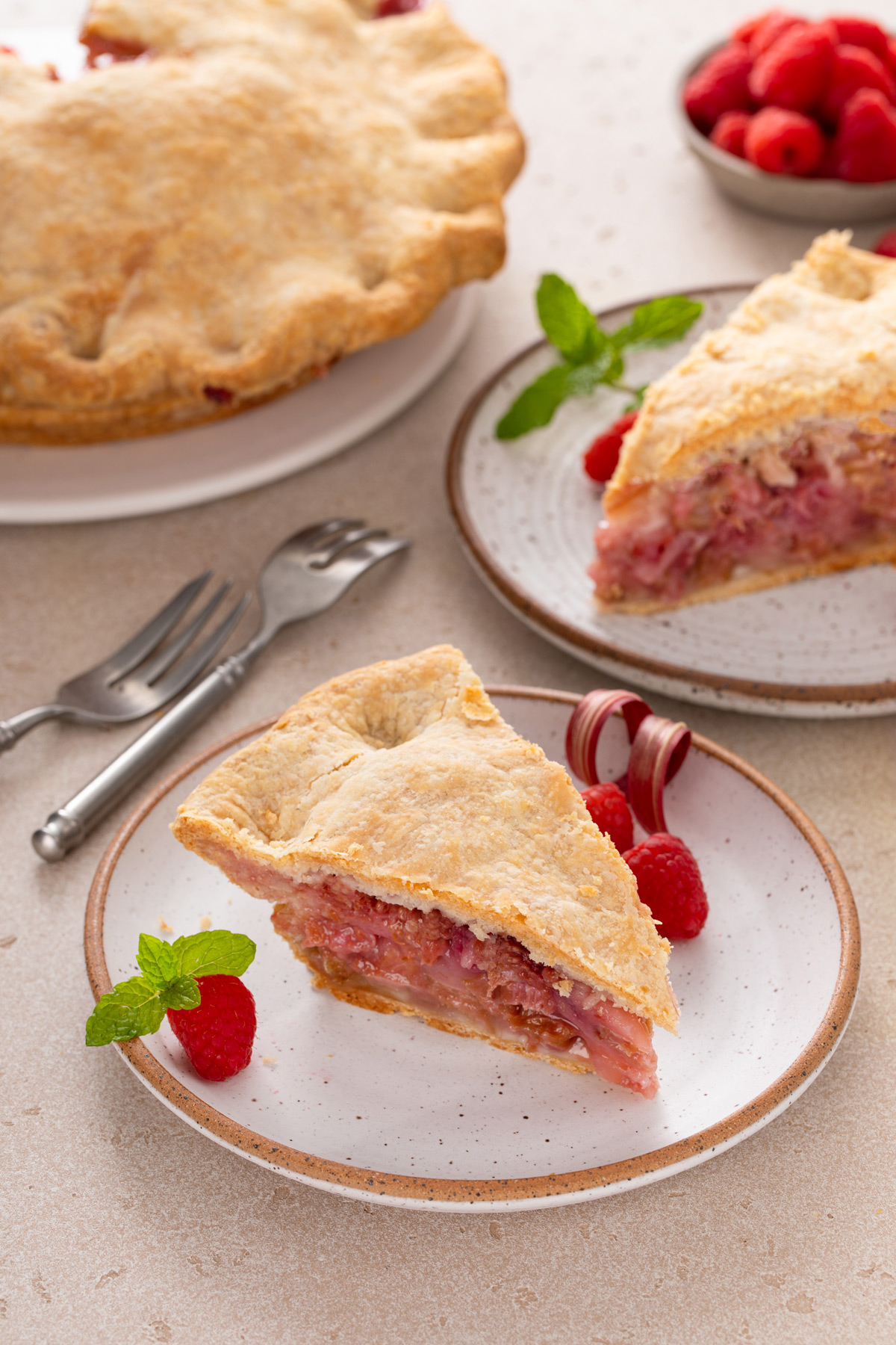 Two plated slices of raspberry rhubarb pie.