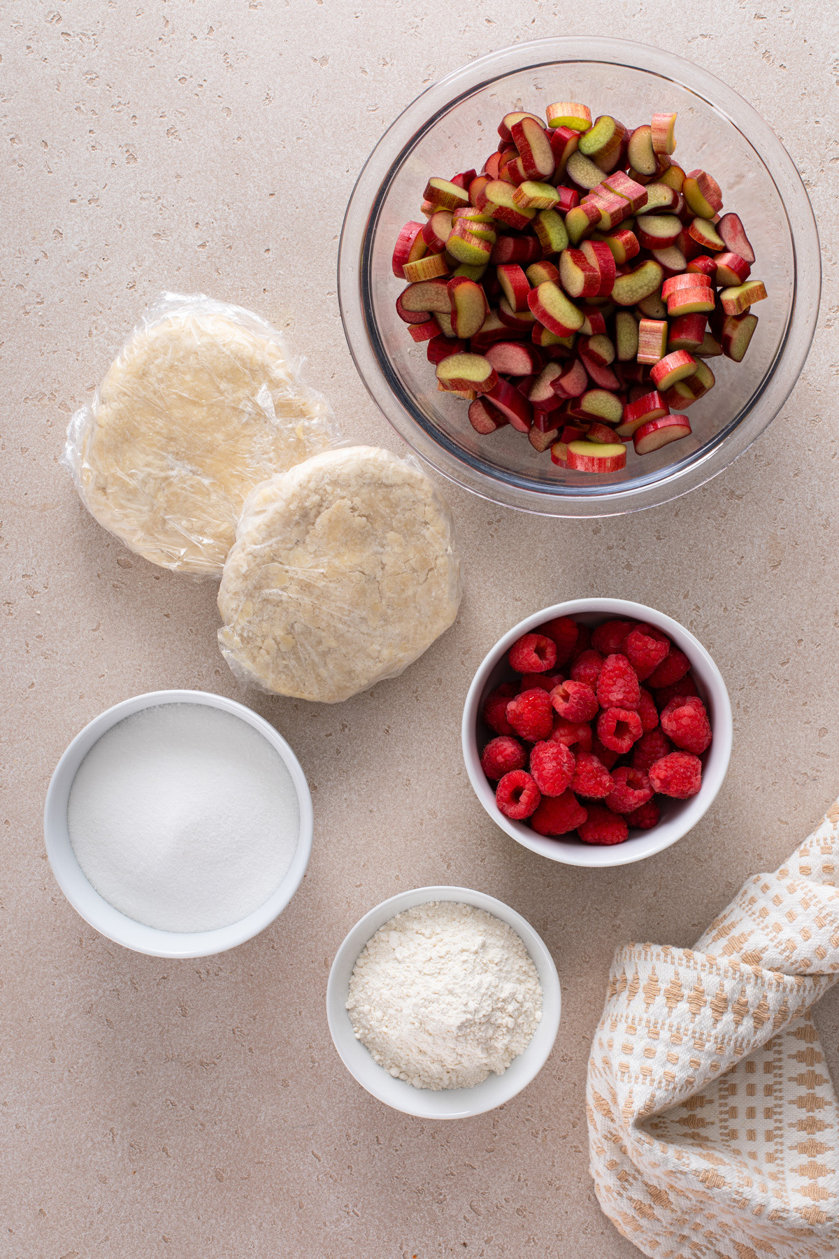 Ingredients for raspberry rhubarb pie arranged on a countertop.