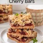 Three sour cherry oat bars stacked on a white plate with a glass of milk in the background. Text overlay includes recipe name.