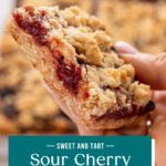 Hand holding up a sour cherry bar to the camera. Text overlay includes recipe name.