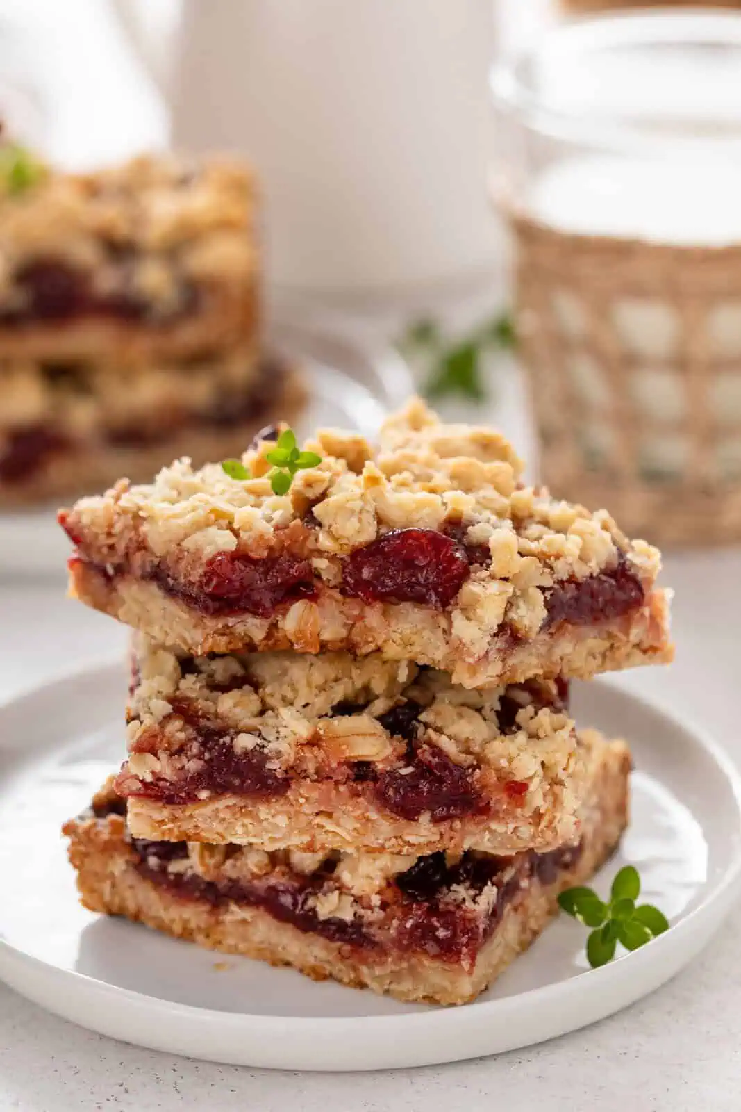 Three cherry bars stacked on a plate with a bite taken from the corner of the top bar.