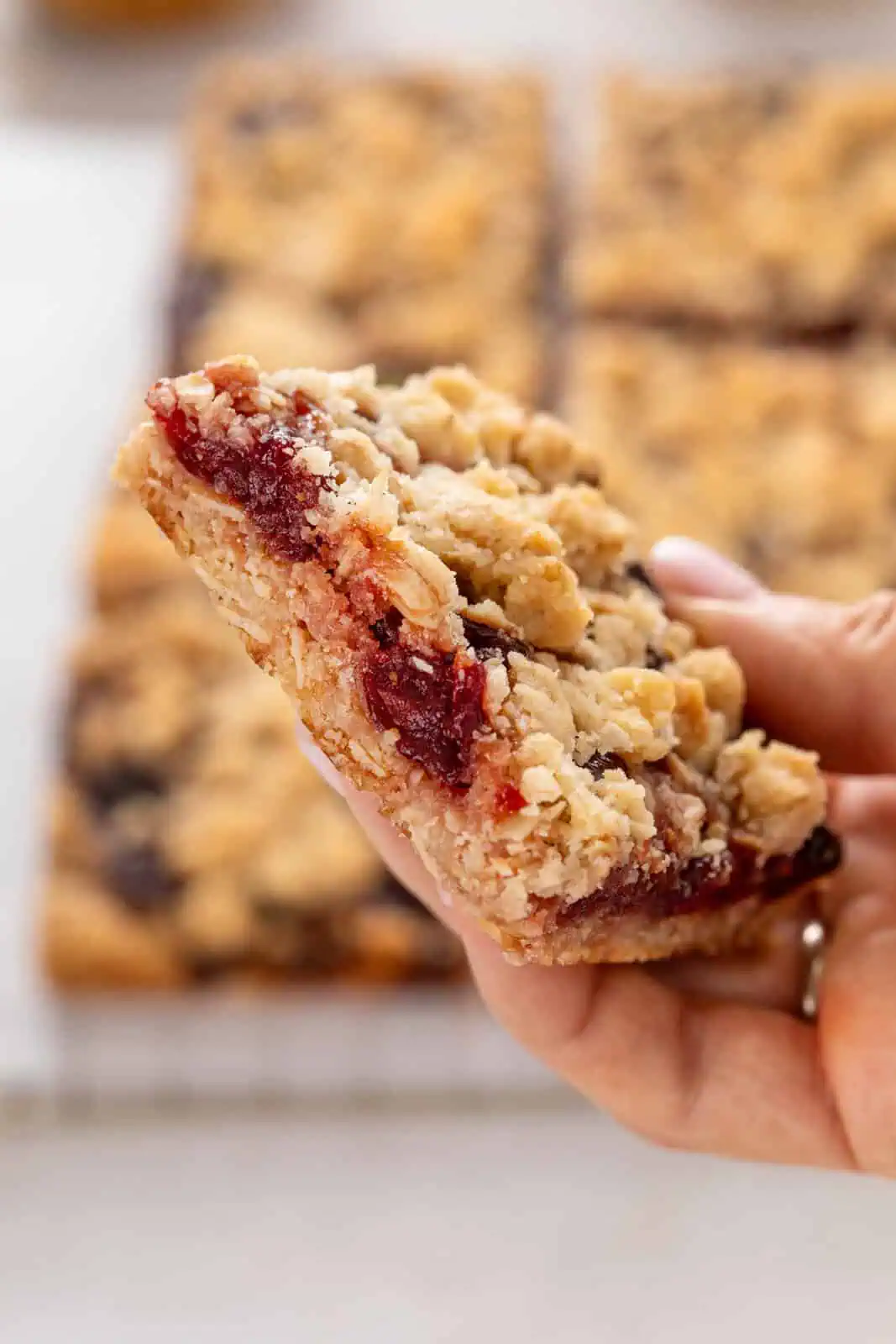 Hand holding up a sour cherry bar to the camera.