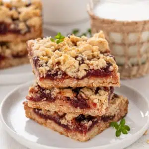 Stacked sour cherry bars on a white plate.