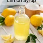 Glass bottle of easy lemon syrup with lemons and sugar in the background. Text overlay includes recipe name.