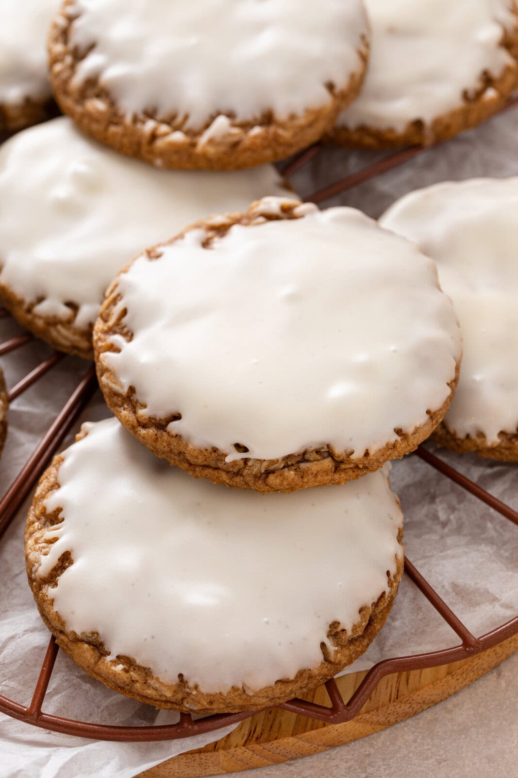Close up of iced oatmeal cookies arranged on a rack.