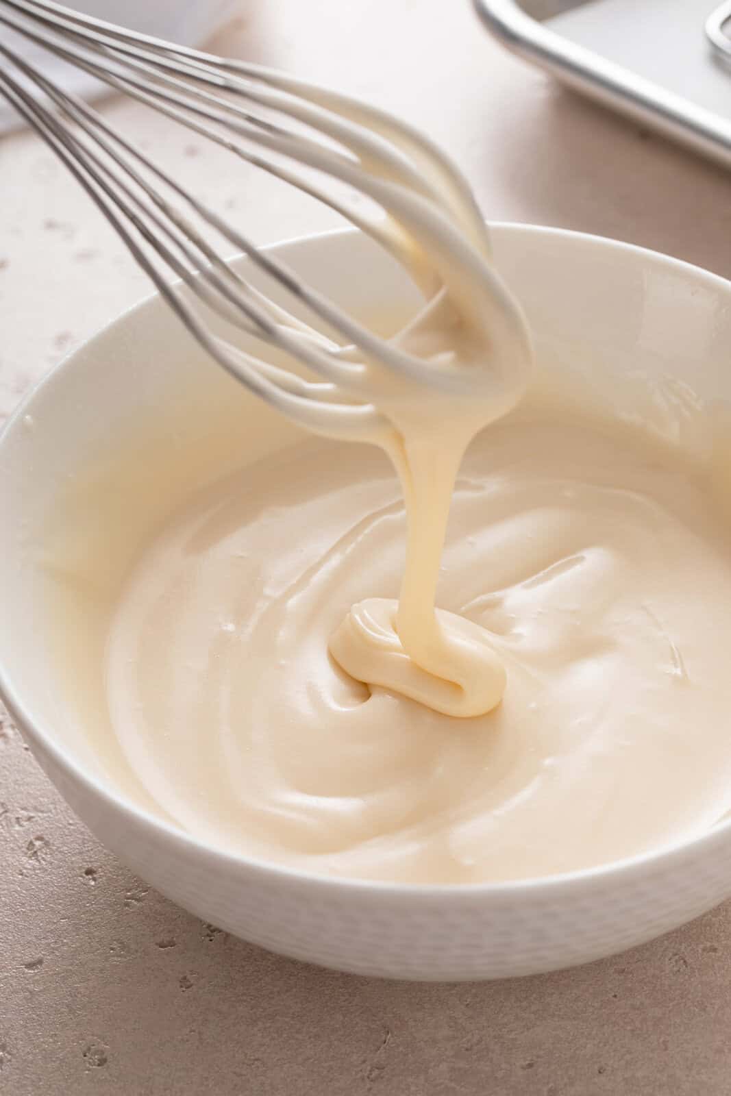 Icing for oatmeal cookies being whisked in a white bowl.