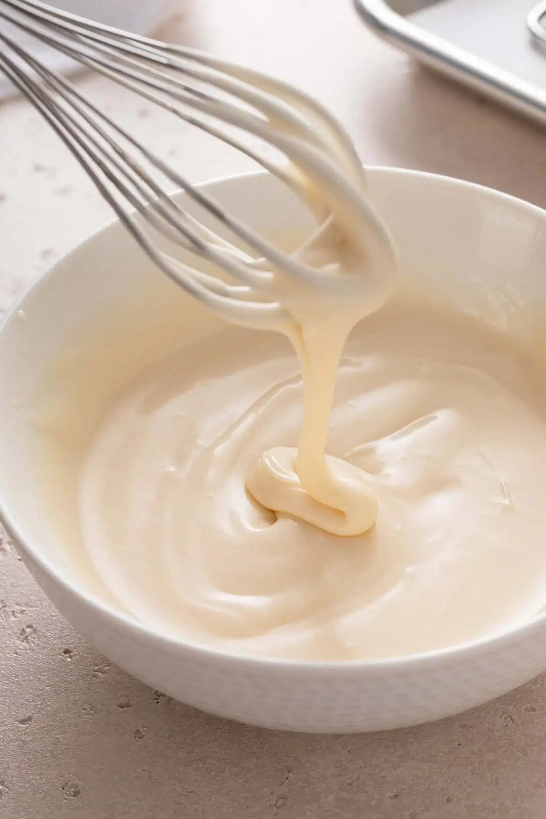 Icing for oatmeal cookies being whisked in a white bowl.