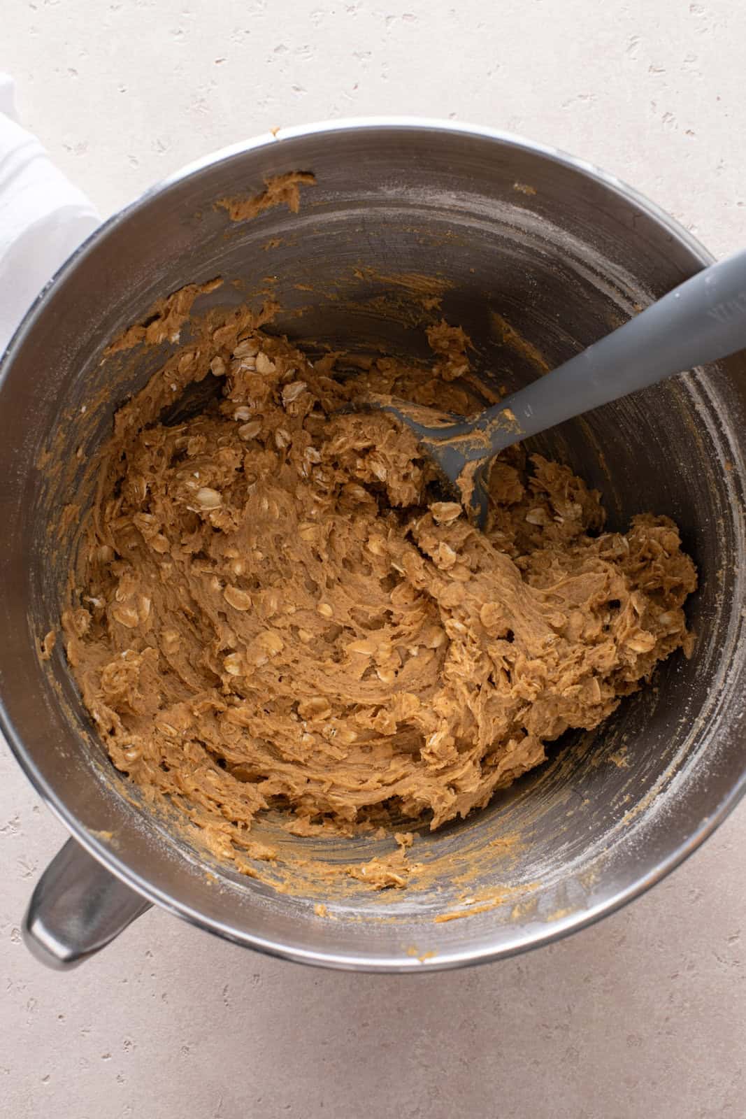 Oatmeal cookie dough in a stainless steel bowl.