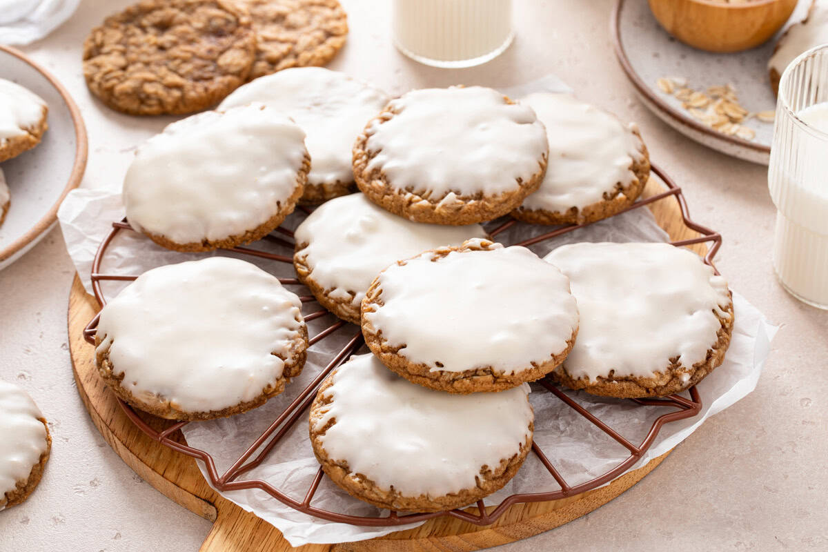 Iced oatmeal cookies arranged on a decorative wire rack.