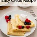Three folded crepes arranged on a white plate and topped with berries and whipped cream. Text overlay includes recipe name.