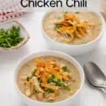 Two white bowls filled with white bean chicken chili and garnished with green onions and tortilla strips. Text overlay includes recipe name.