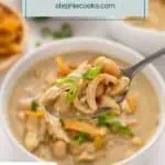 Spoonful of white bean chicken chili over a bowl of the chili. Text overlay includes recipe name.
