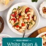 Overhead view of white bean and artichoke salad on a countertop. Text overlay includes recipe name.