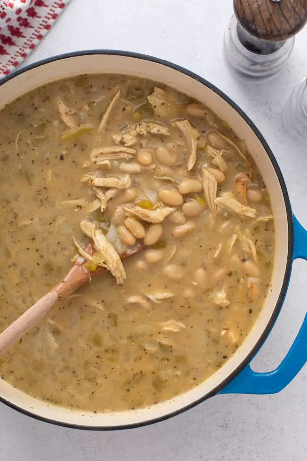 Cheese melted into white bean chicken chili in a dutch oven.
