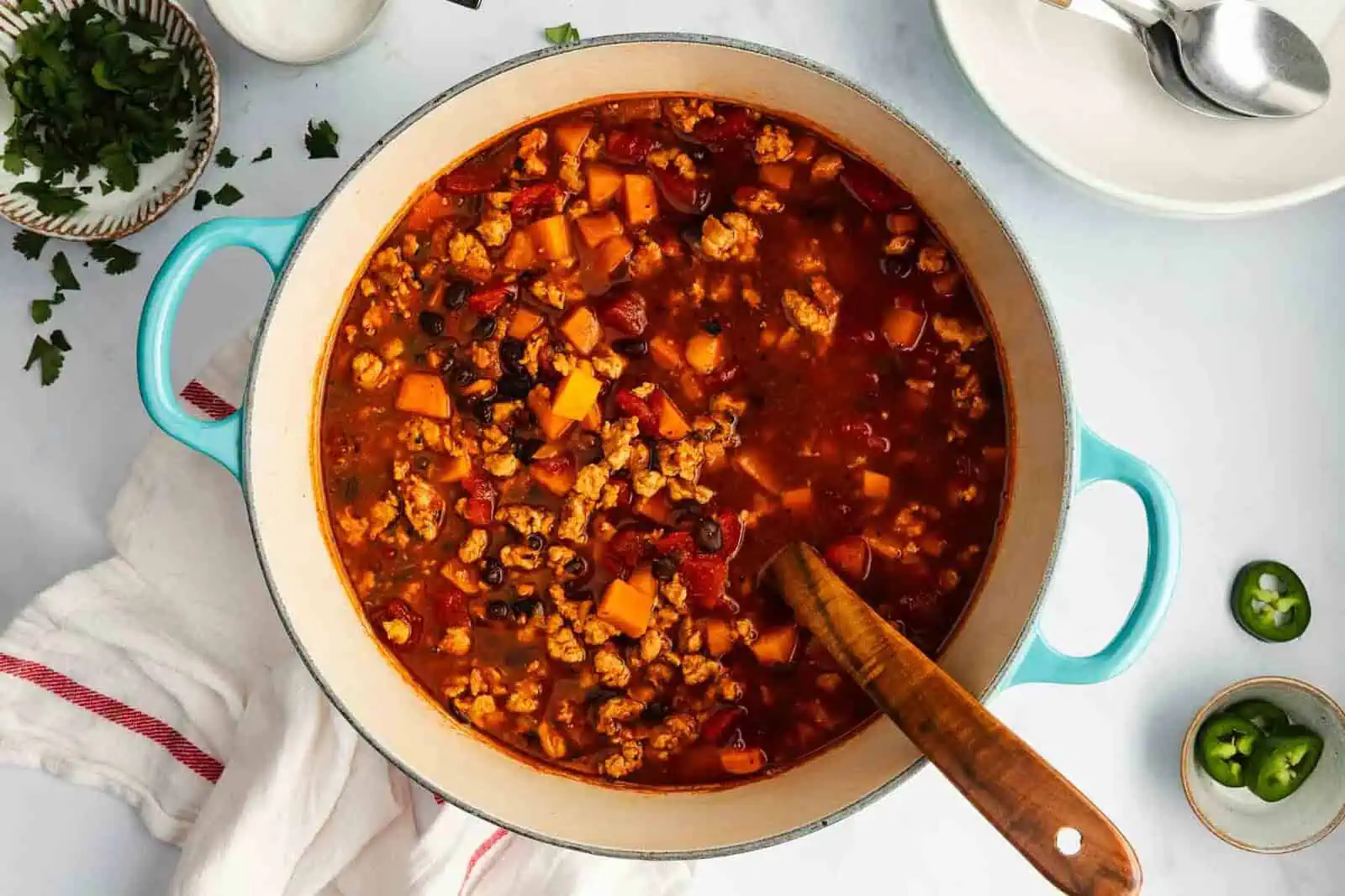 Overhead view of a blue dutch oven filled with turkey sweet potato chili.