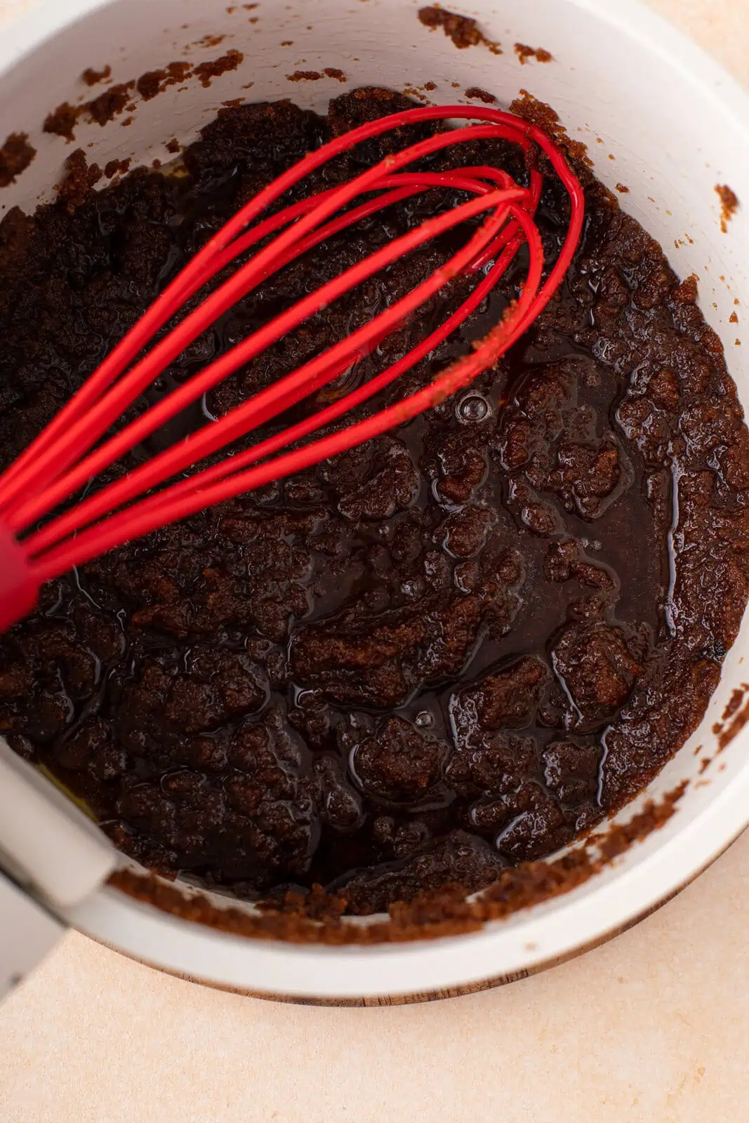 Dark brown sugar mixed with brown butter in a saucepan.