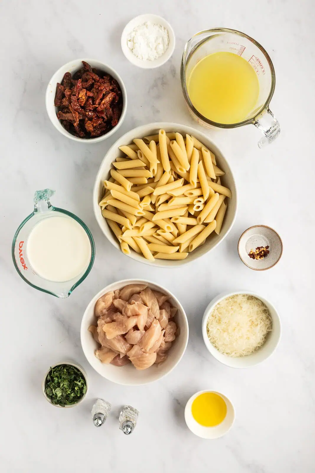 Ingredients for sun-dried tomato pasta arranged on a countertop.