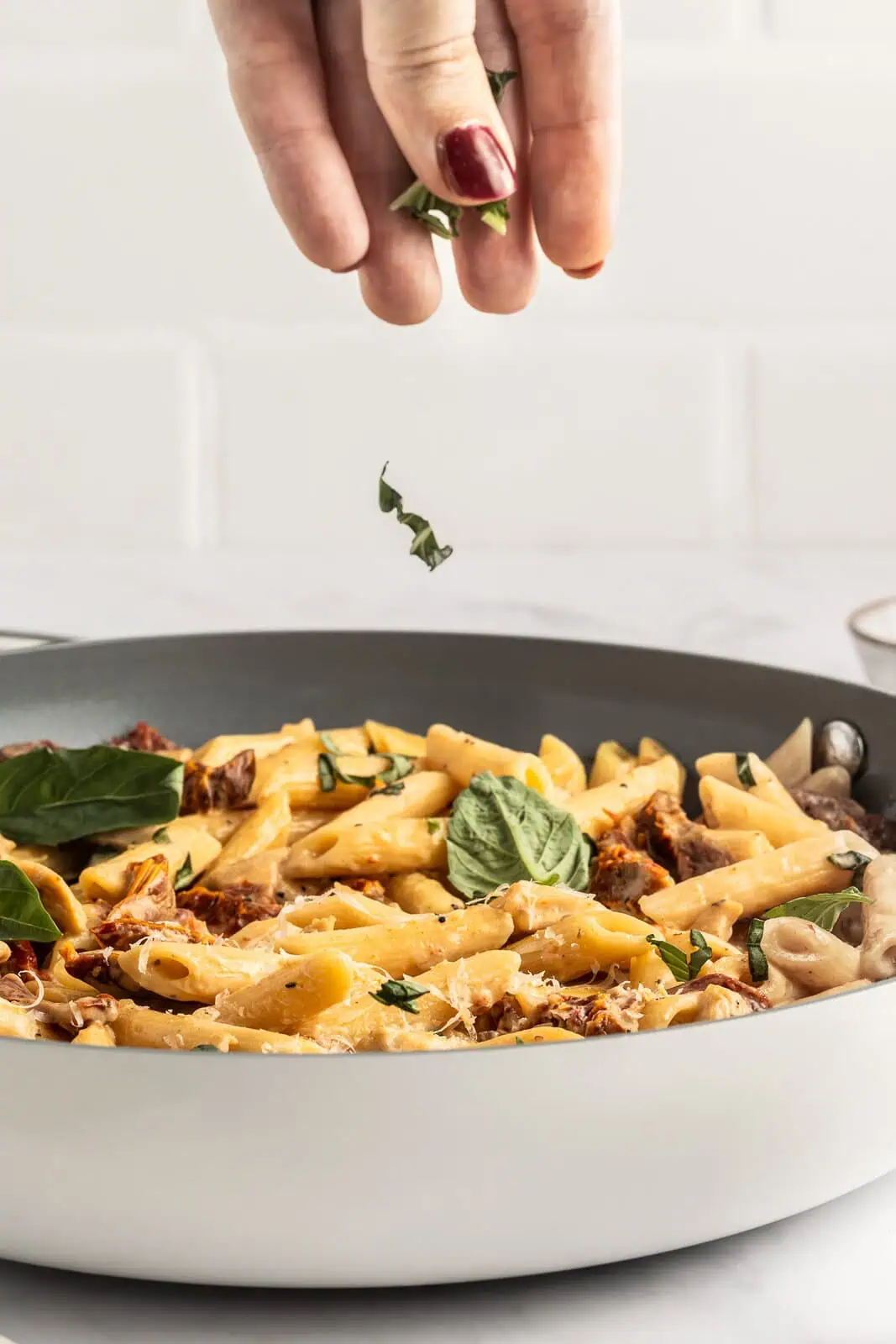 Delicious sun-dried tomato chicken pasta with fresh basil and Parmesan cheese. Perfect for a flavorf.