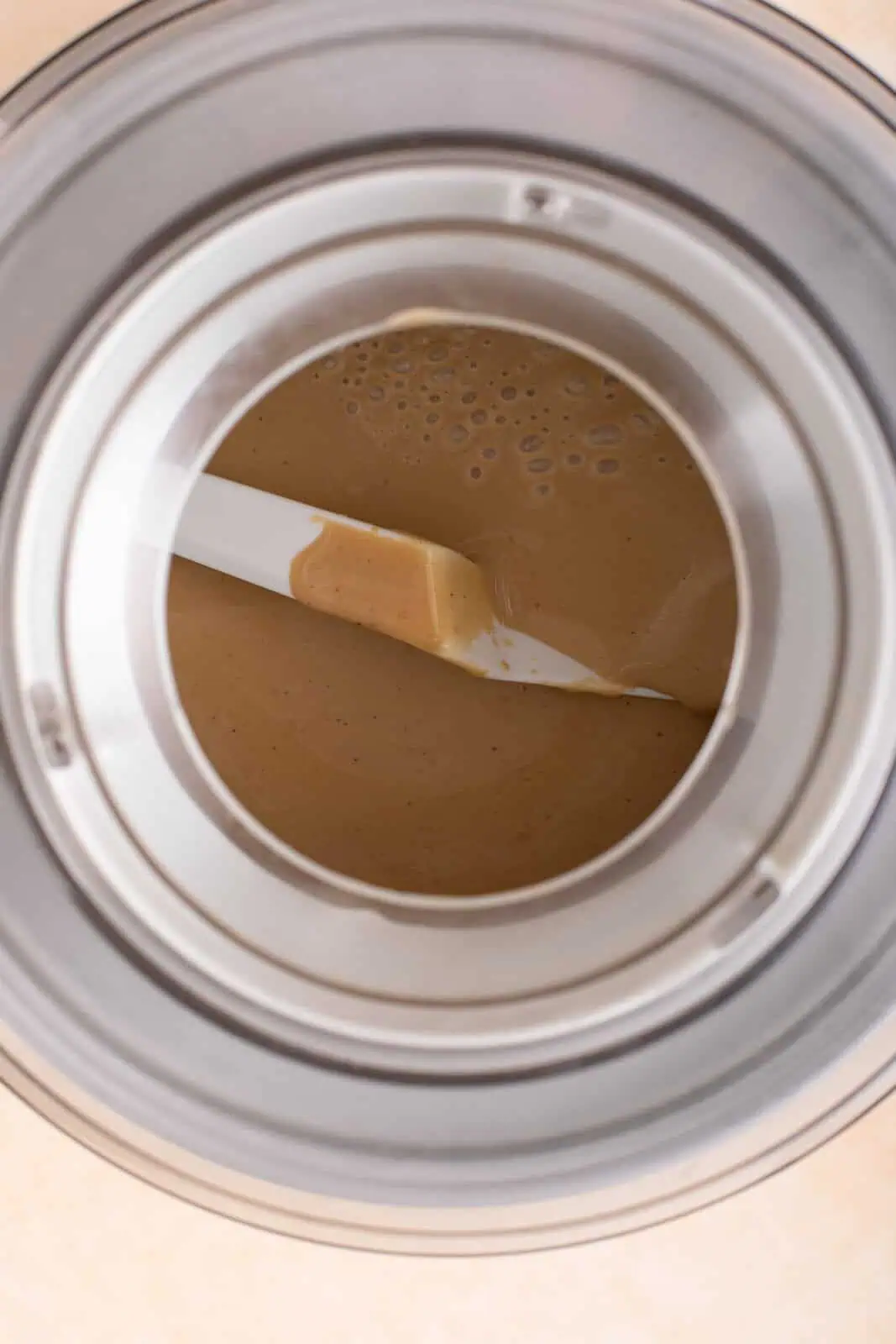 Custard ice cream base for butter pecan ice cream added to an ice cream maker.