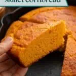 Hand picking up a slice of sweet potato cornbread from a skillet. Text overlay includes recipe name.