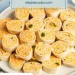 Sliced buffalo chicken pinwheels arranged on a white platter. Text overlay includes recipe name.