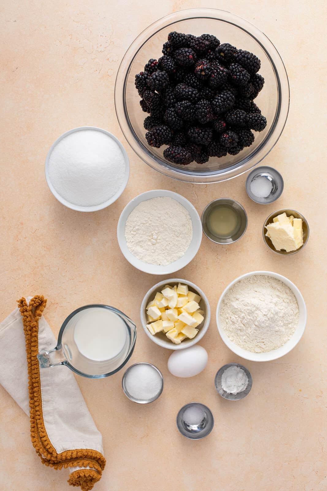 Ingredients for biscuit-topped blackberry cobbler arranged on a countertop.