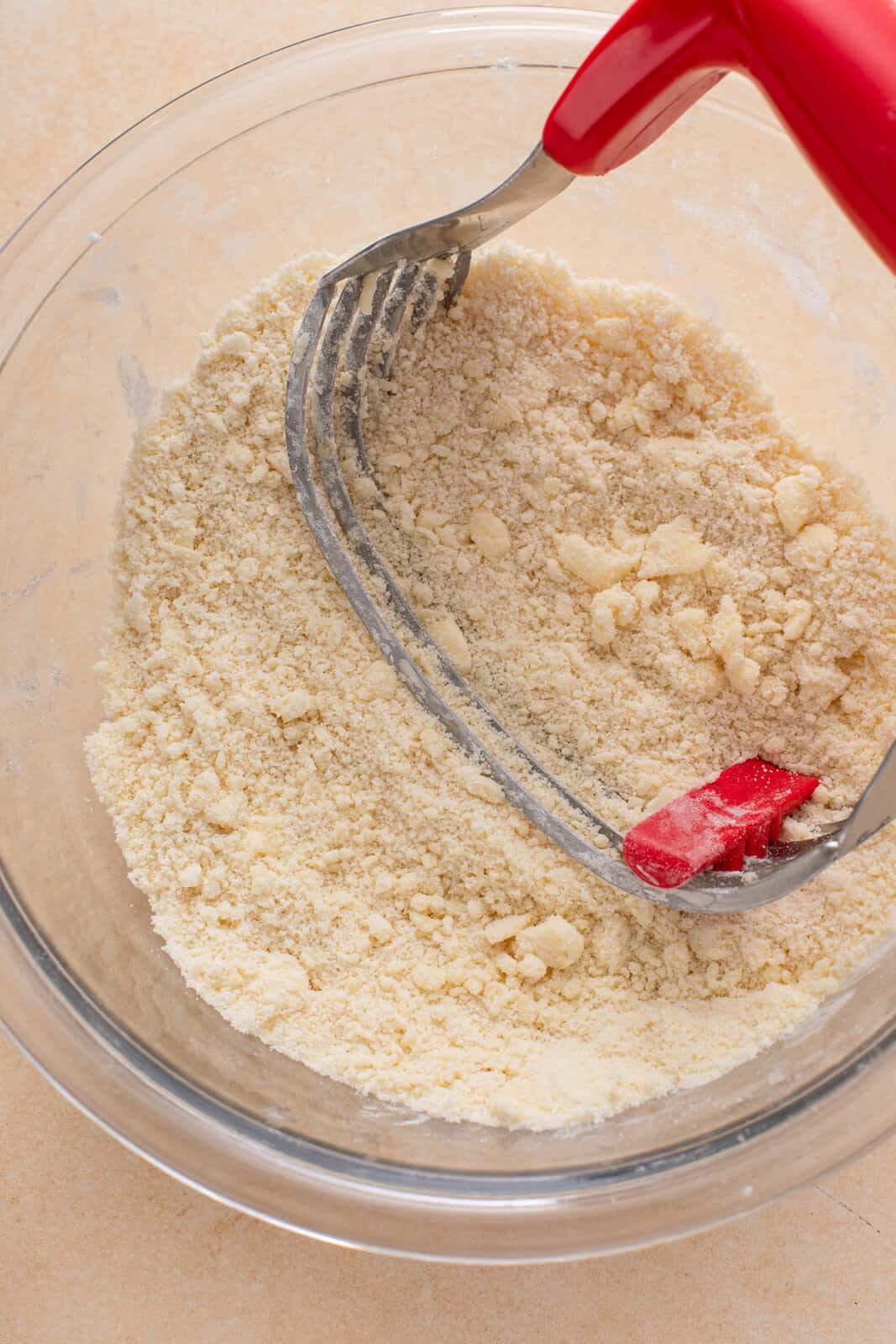 Butter being cut into dry ingredients for cobbler topping.
