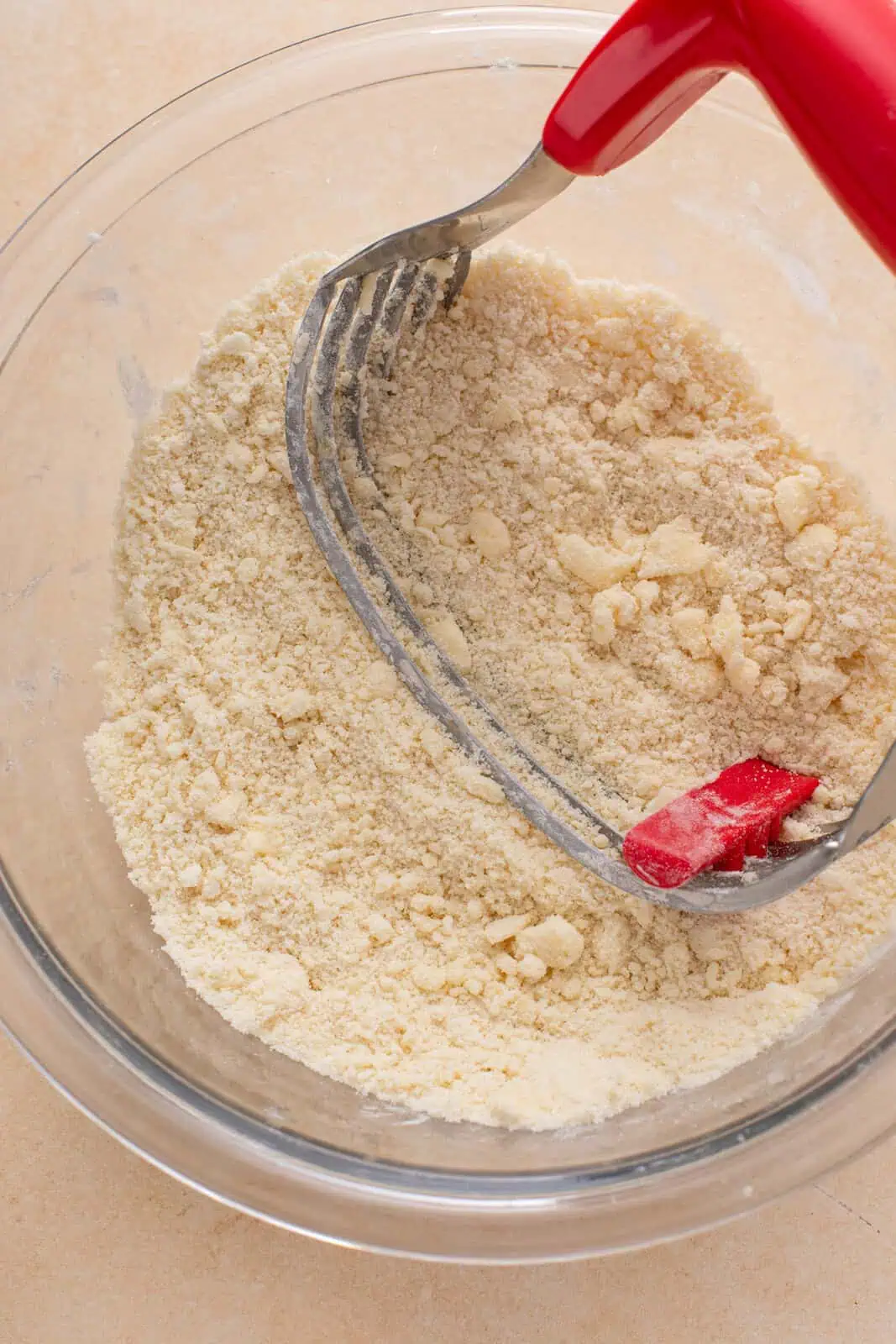 Butter being cut into dry ingredients for cobbler topping.
