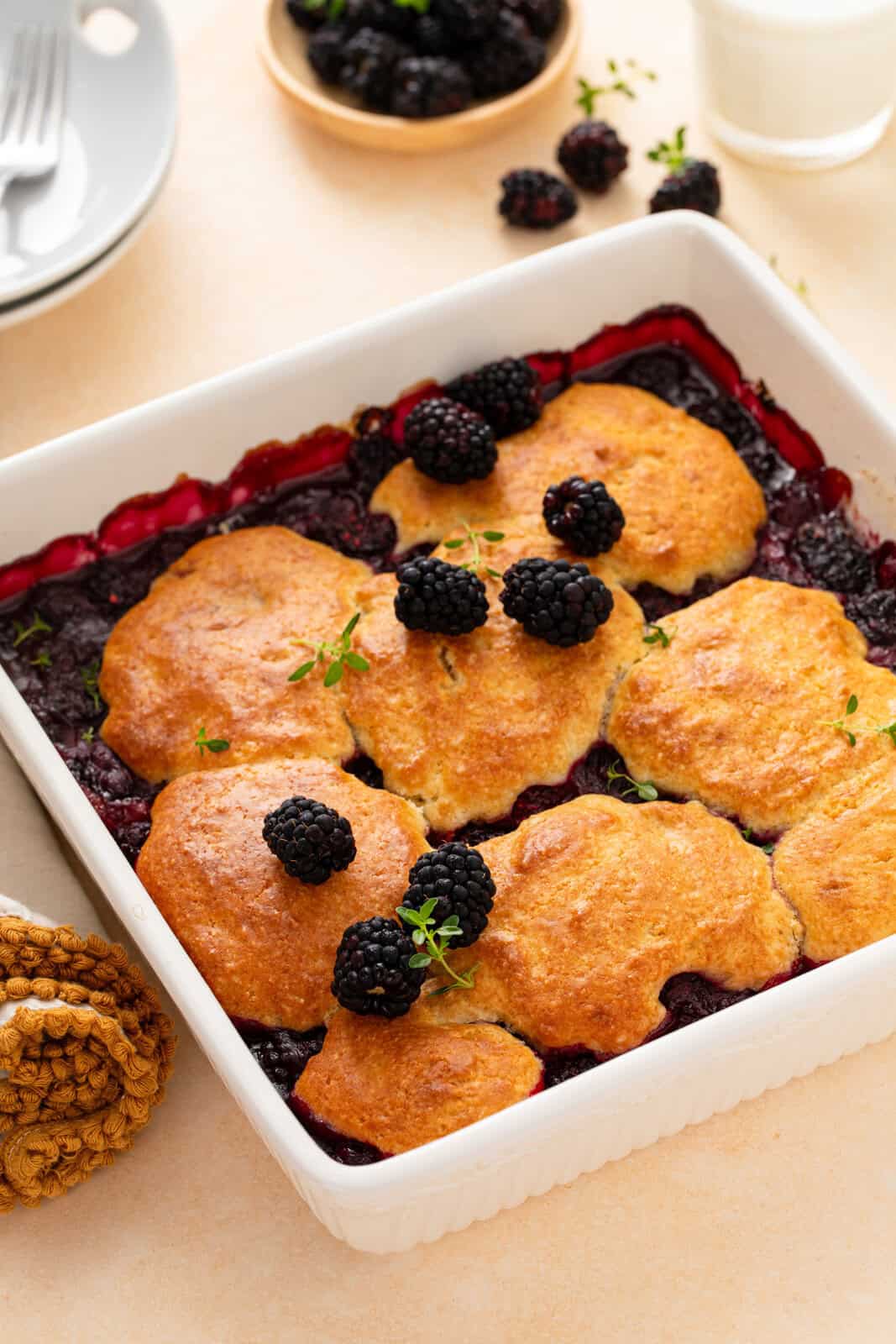 Cooled biscuit-topped blackberry topping in a white dish.