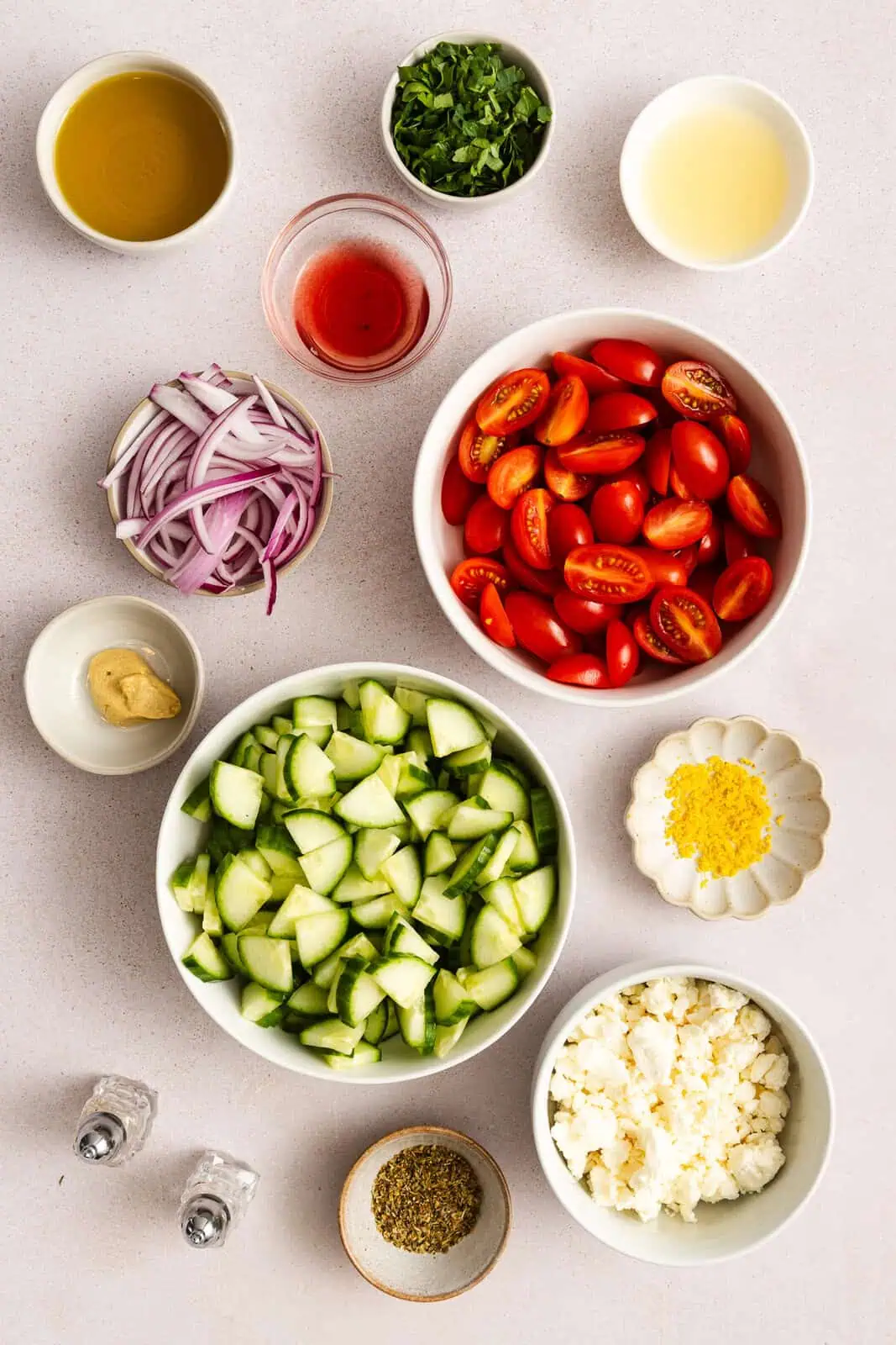 Ingredients for cucumber feta salad arranged on a countertop.